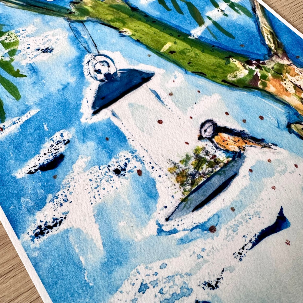 Gros plan d’une illustration aquarelle représentant une mangeoire suspendue à une branche, avec un petit oiseau posé dessus. Les détails de la texture du papier et les nuances de bleu et de vert créent une atmosphère douce et naturelle. Appartient à Boutique de Moments.