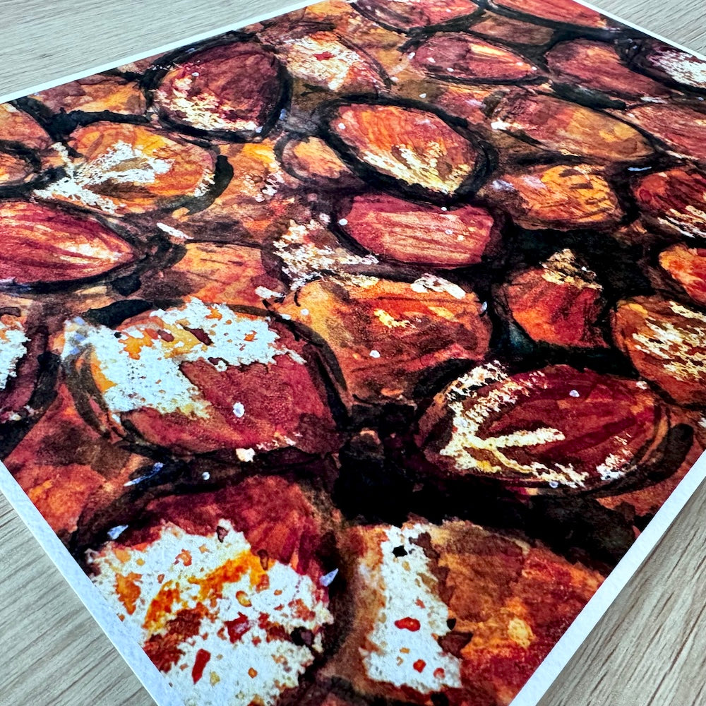 Gros plan d’une illustration aquarelle représentant des noisettes aux teintes chaudes de brun, rouge et ocre. La texture du papier met en valeur les détails organiques et les nuances automnales de la composition. Appartient à Boutique de Moments.