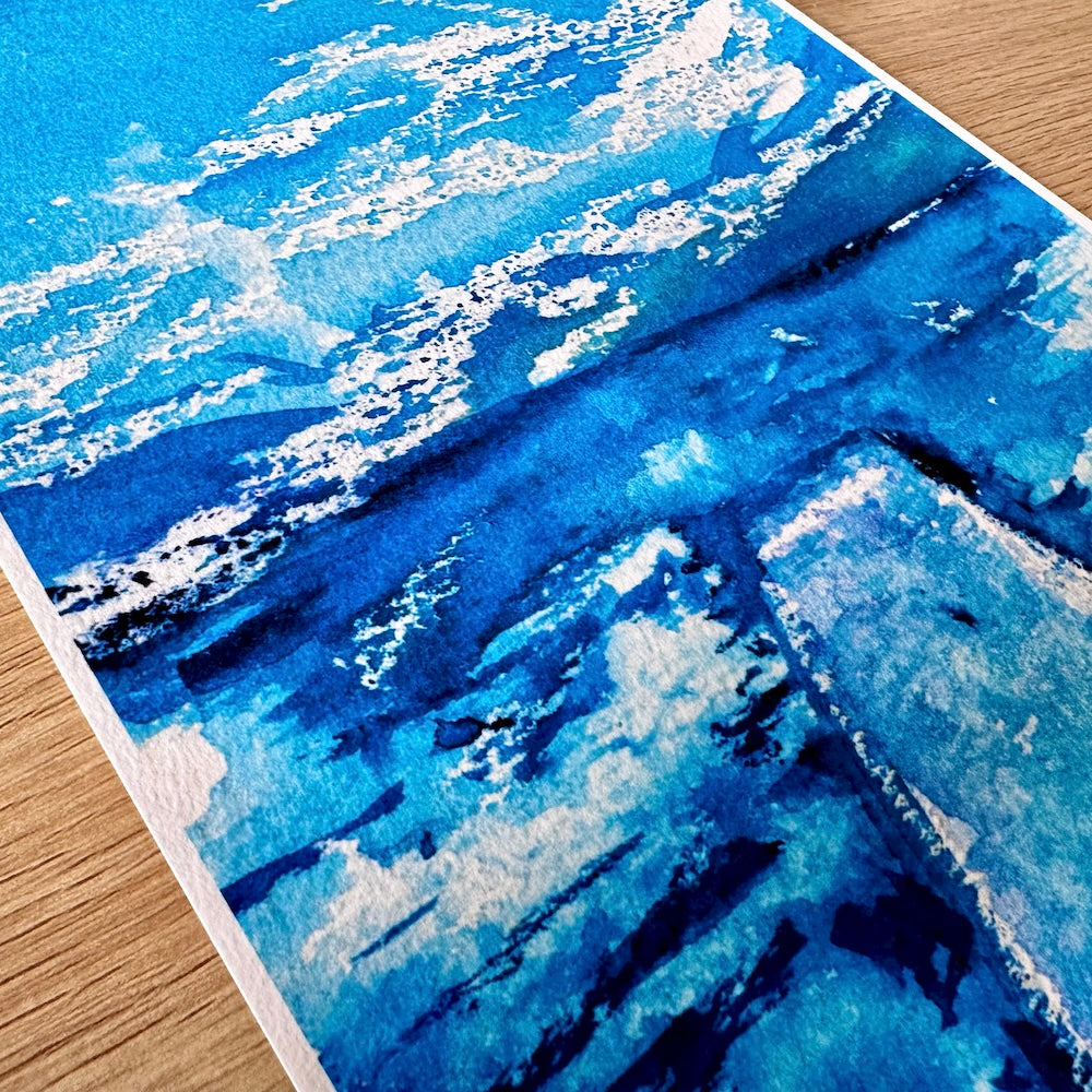 Gros plan d’une illustration aquarelle montrant un plongeoir s’avançant sur un lac aux eaux bleues profondes, sous un ciel lumineux parsemé de nuages blancs. Les textures aquarellées soulignent la fluidité et la tranquillité de la scène. Appartient à Boutique de Moments.